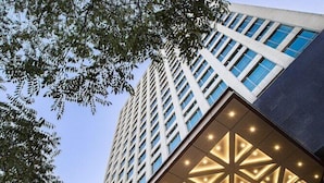 A hotel with a modern facade, a geometric patterned ceiling, and a sign indicating it is a Holiday Inn. - Holiday Inn Taiyuan City Center (Taiyuan)