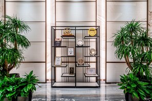 A display case with awards and plaques, surrounded by potted plants. - Holiday Inn Taiyuan City Center (Taiyuan)