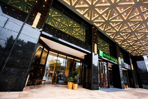 A modern hotel entrance with a geometric ceiling design, large glass doors, and a sign indicating it's a Holiday Inn. - Holiday Inn Taiyuan City Center (Taiyuan)