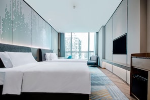 Un hotel moderno con una cama grande, televisión y vistas a la ciudad.