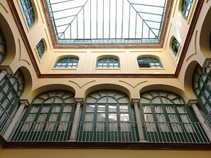A building with a central skylight, multiple arched windows, and a symmetrical facade. - Apartment with 3 bedrooms, 1 bathroom. 2 min walk from the Cathedral. 5 guests (Sevilla)