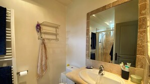 A bathroom with a toilet, sink, and mirror.