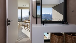 Et moderne badeværelse med et stort spejl, hvid bordplade og fletkurve.