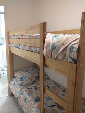 Uma cama beliche com roupa de cama floral e estrutura de madeira.