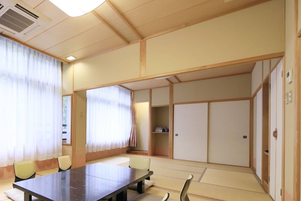 Een traditionele Japanse kamer met tatami vloeren, een lage tafel en schuifdeuren.