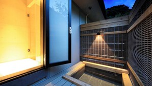 Un intérieur moderne avec une porte en verre donnant sur une pièce, un banc en bois et un petit élément décoratif aquatique.
