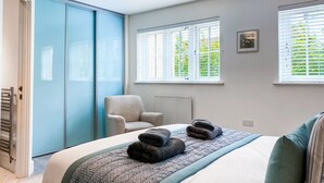 A bedroom with a bed, a chair, and a radiator. - Stylish, City Centre 3-bed House With Parking (Canterbury)