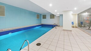 An indoor swimming pool with clear blue water, tiled walls, and a tiled floor. - Central modern North Sydney 2 bed apartment with gym and pool (North Sydney)