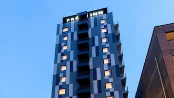A tall building with a checkered facade and balconies.
