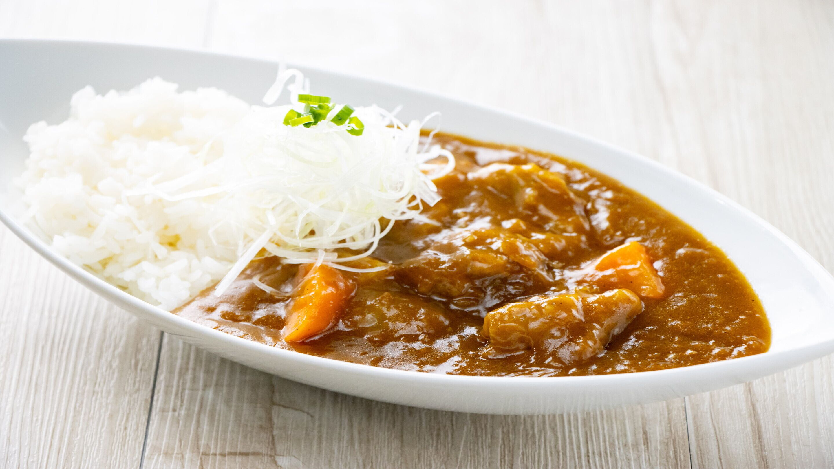 A dish with rice and shredded vegetables on a white plate.