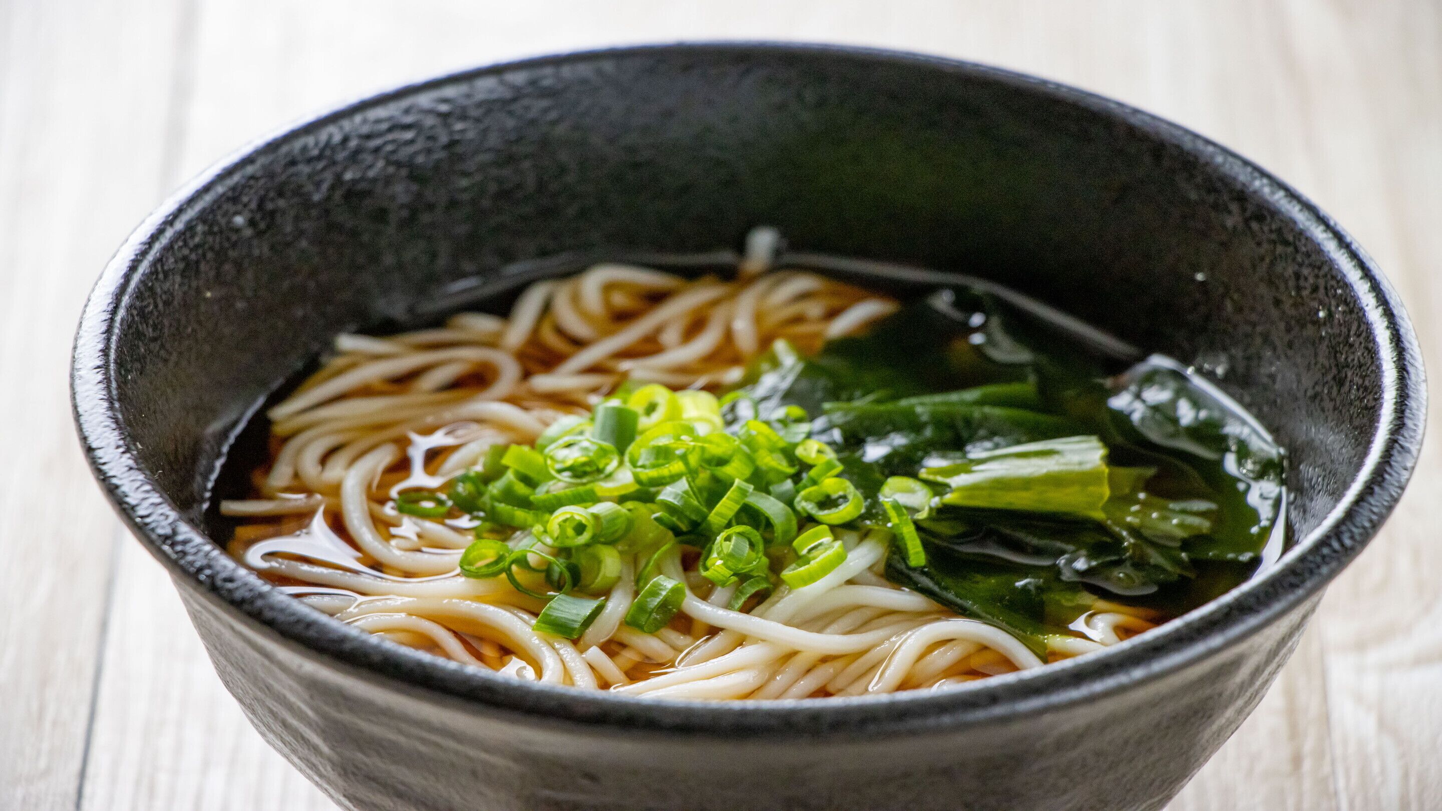 Eine Schüssel Ramen mit Nudeln, Frühlingszwiebeln und Seetang.