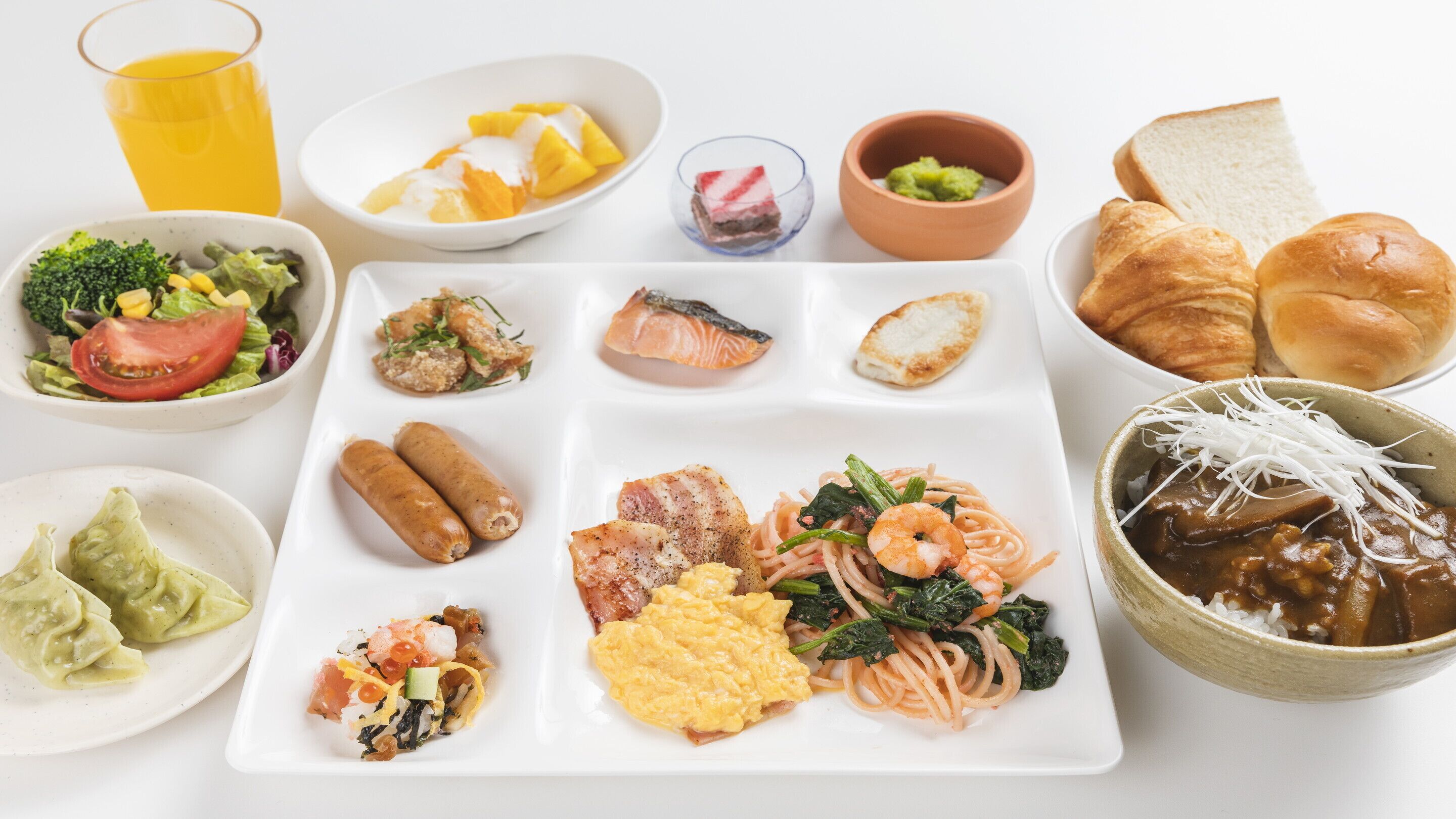 A variety of dishes including sushi, sashimi, and a plate with eggs, shrimp, and vegetables.