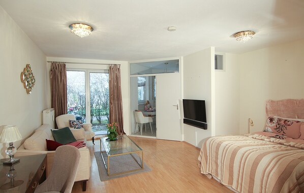 A spacious living room with a sofa, coffee table, and a TV mounted on the wall. - ☆Luxurious apartment☆ Central MUC Enjoy & relax (München)