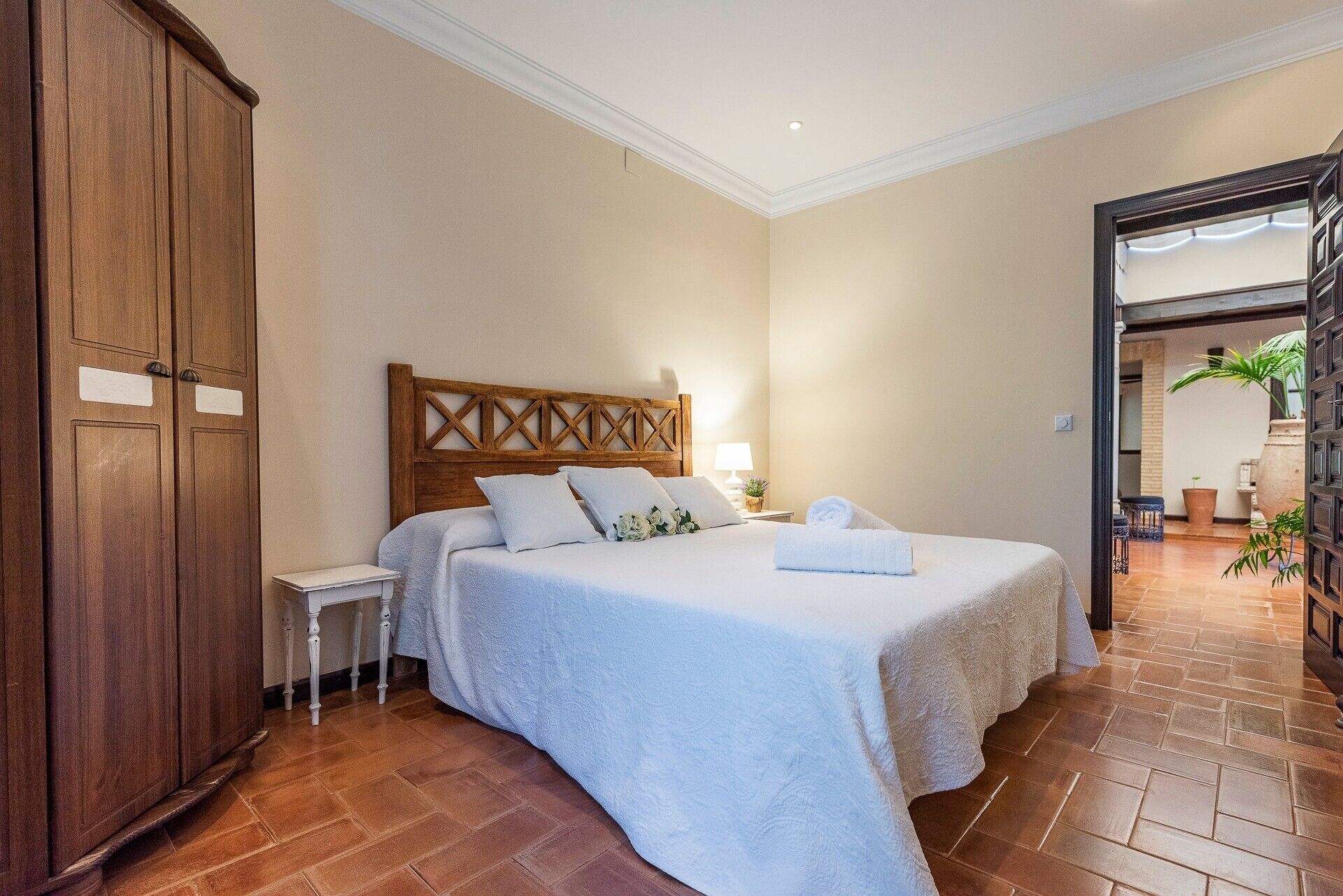 Ein Hotelzimmer mit einem Bett, einem Holzschrank und Blick ins Freie.