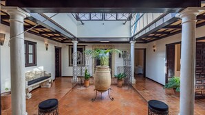 A spacious courtyard with a tiled floor, columns, a bench, and potted plants. - Holiday Home "Casa Rural La Teja" with Pool, Garden and Wi-Fi (Marchena)