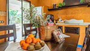 A kitchen with a copper bucket containing a plant, a plate of oranges and kiwis, and a container of snacks. - Holiday Home "Casa Rural La Teja" with Pool, Garden and Wi-Fi (Marchena)