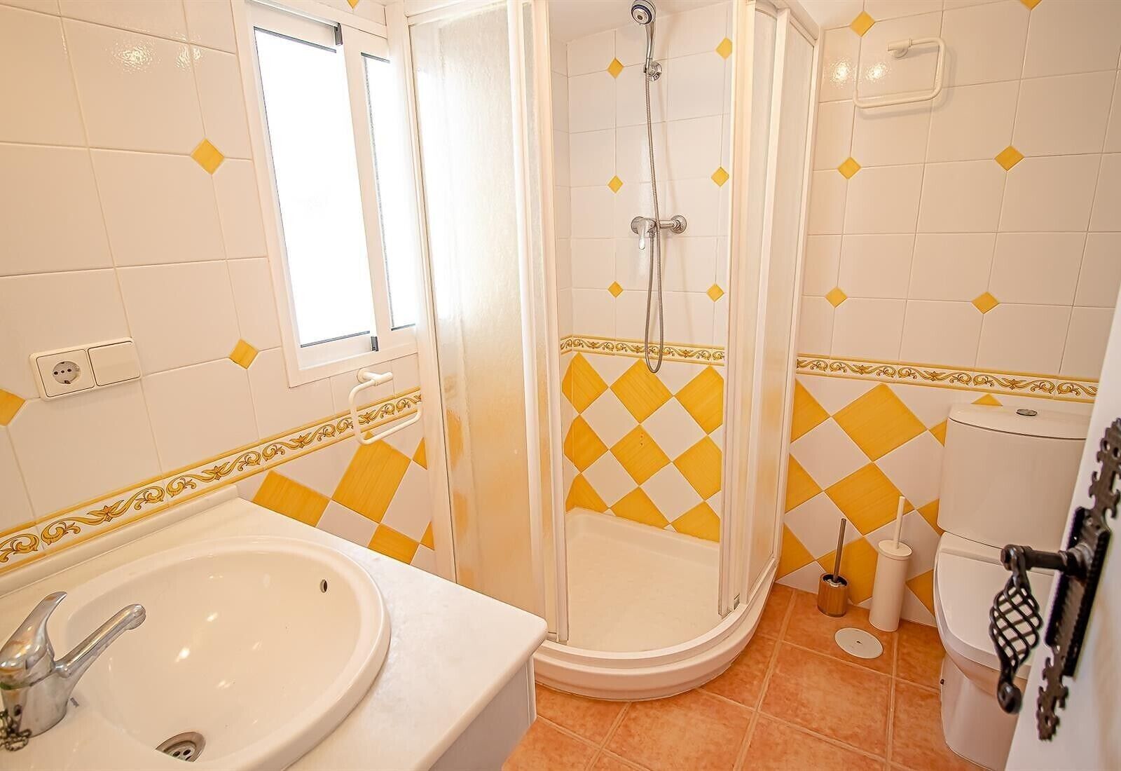 A bathroom with a shower, toilet, and sink.
