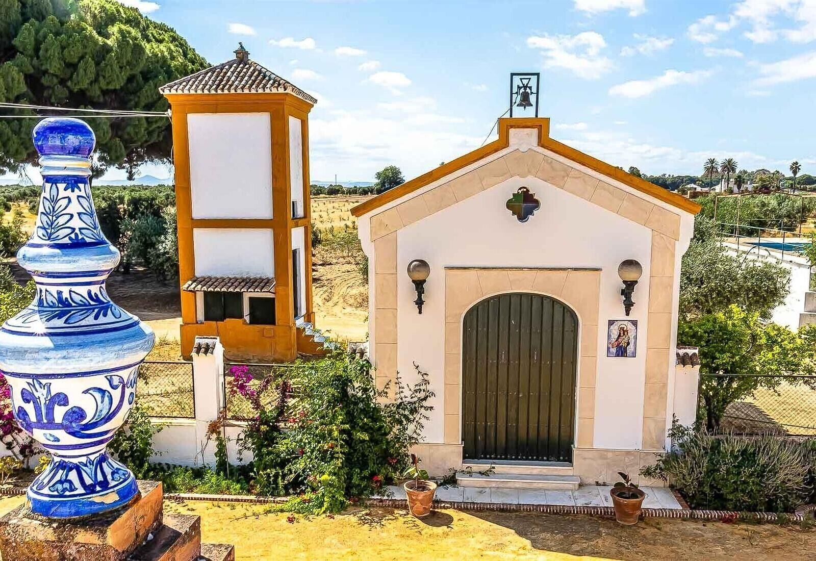 A small chapel with a bell tower and a statue.