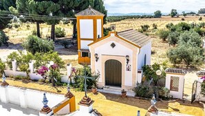 Un piccolo edificio con tetto in tegole, un'unica porta centrale e una piccola struttura simile a una torre.