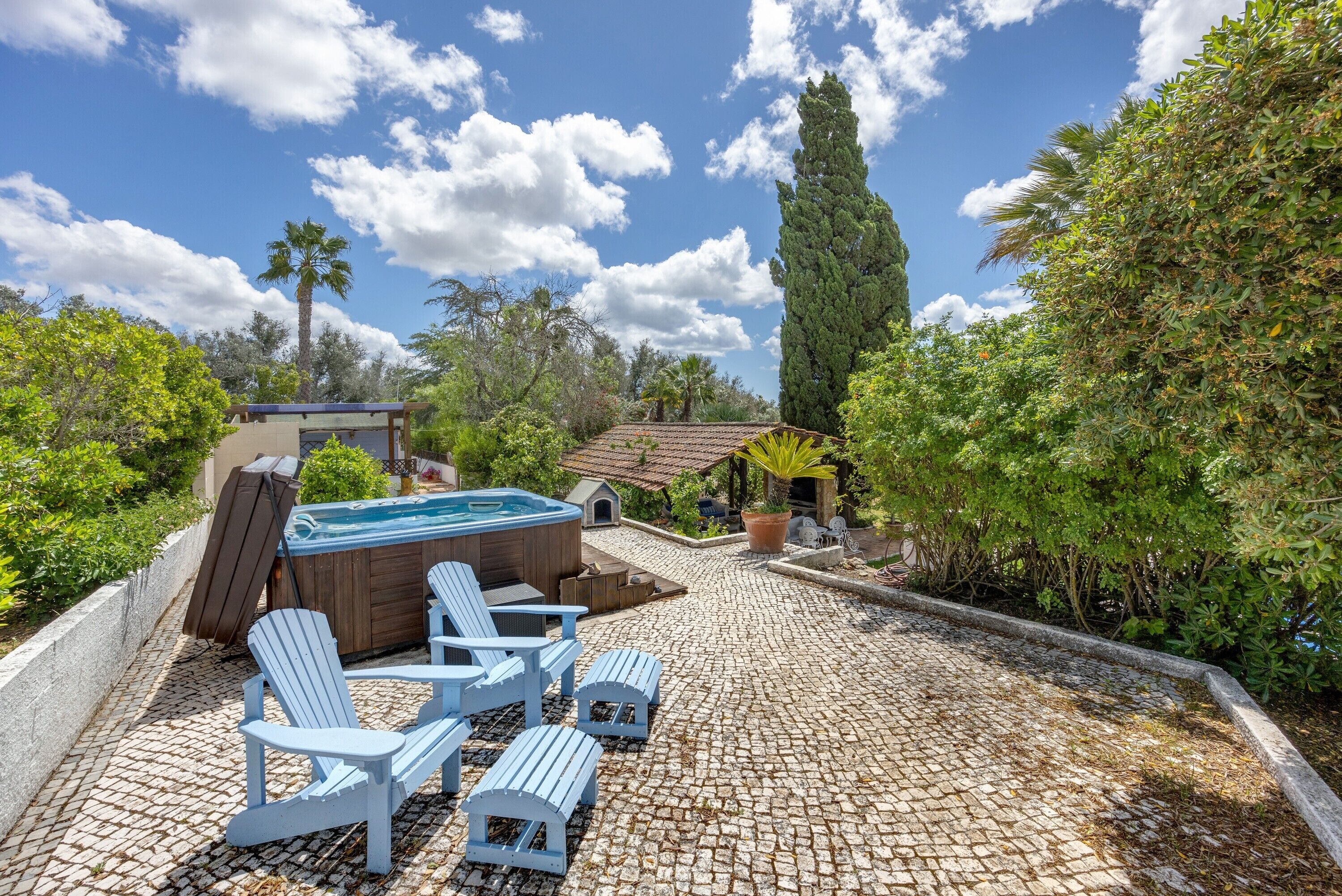 A hot tub, lounge chairs, and a stone patio.