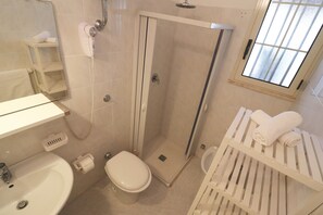 Une salle de bain équipée d’une douche, de toilettes, d’un lavabo et d’un porte-serviettes.
