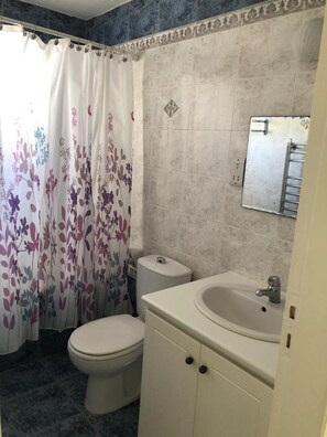 A bathroom with a toilet, a sink, and a shower curtain with a floral pattern. - Charming 3-bed Villa in Protaras With Heated Pool (Paralimni)