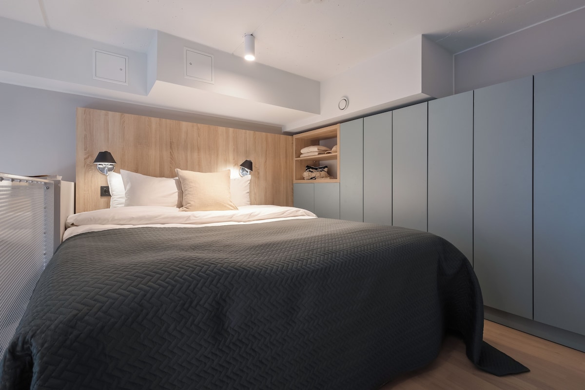 Ein modernes Schlafzimmer mit einem großen Bett, einem Holzkopfende und einem Einbauschrank.
