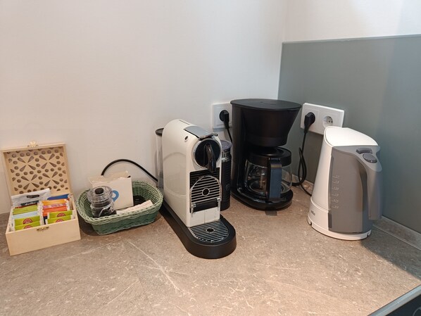 A kitchen with a coffee maker, a kettle, and a toaster on the counter. - Beachhouse with garden and sauna just 700m from the beach (Schönberg)