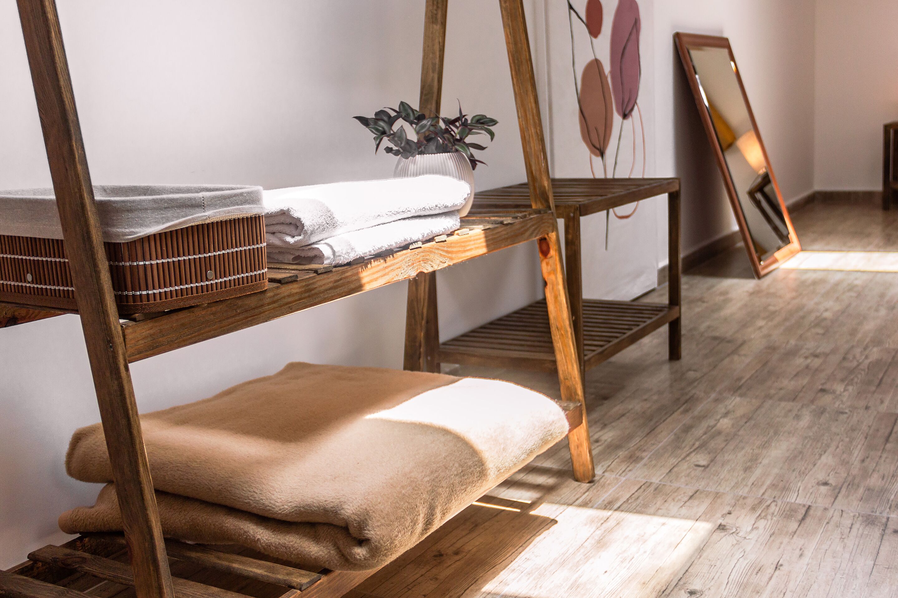 Un lit superposé en bois, avec une serviette blanche et une couverture beige sur le lit du bas.