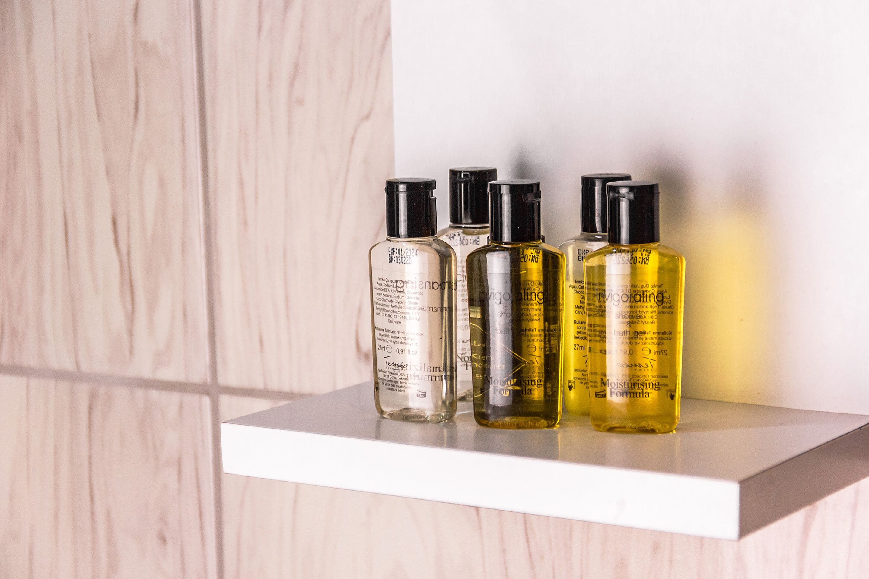 A shelf with four bottles of skincare products.