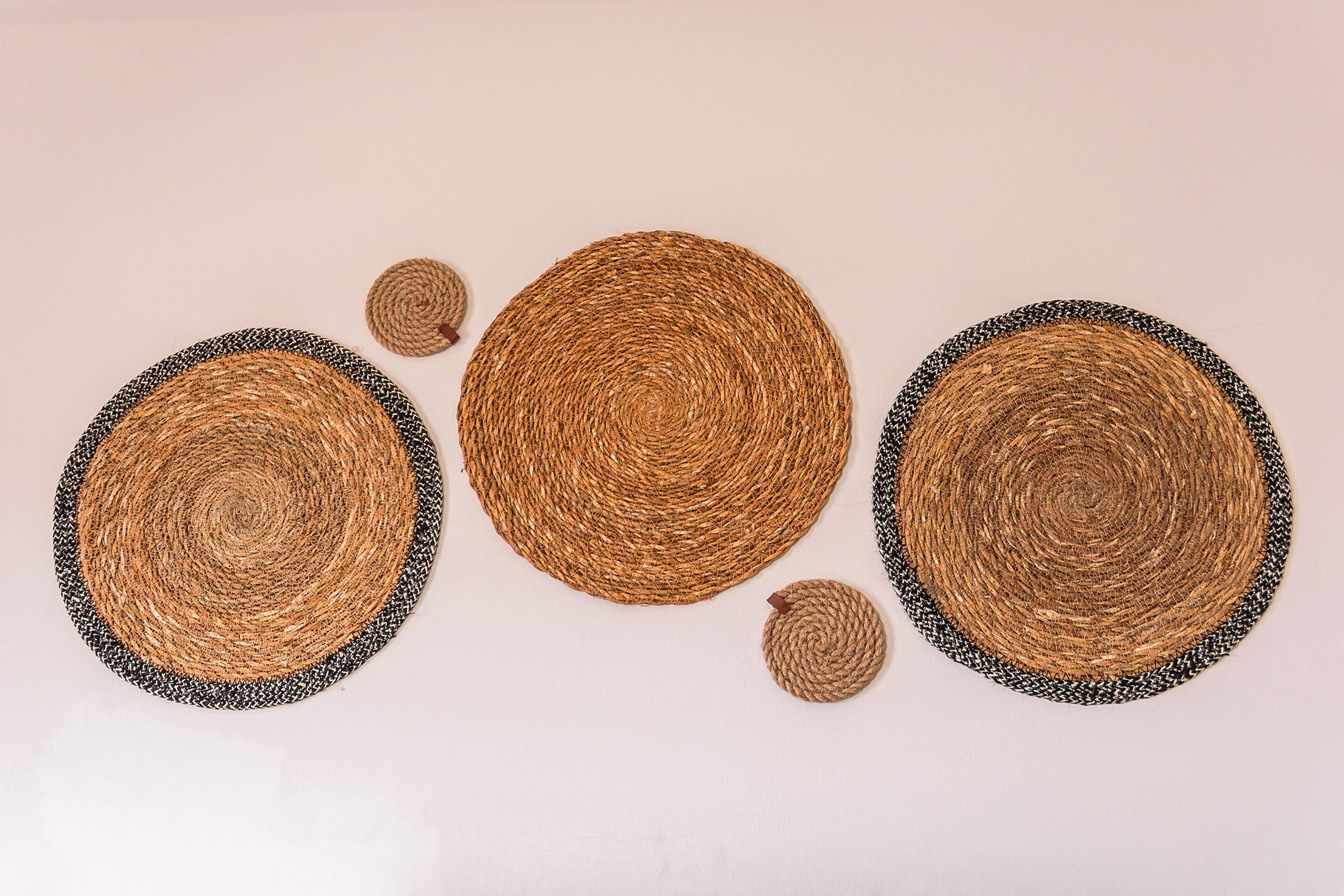 Three circular woven placemats with black and white borders.
