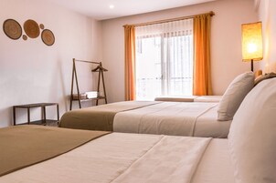 Habitación de hotel con dos camas, una ventana con cortinas, una mesita de noche y decoración en la pared.