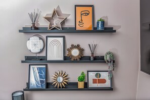 Eine Wand mit drei Regalen, die verschiedene Dekoartikel zeigen.