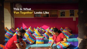 Two people playing a board game on a colorful sofa with zigzag patterned cushions. - goSTOPS Kasol (Bhuntar)
