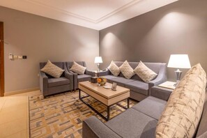 Suíte família, várias camas | Área de estar | TV LED 32 polegadas com canais via satélite, monitores de computador