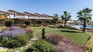 A hotel with multiple guest rooms, a swimming pool, and well-maintained gardens. - Akrolithos luxury suites (Nea Propontida)