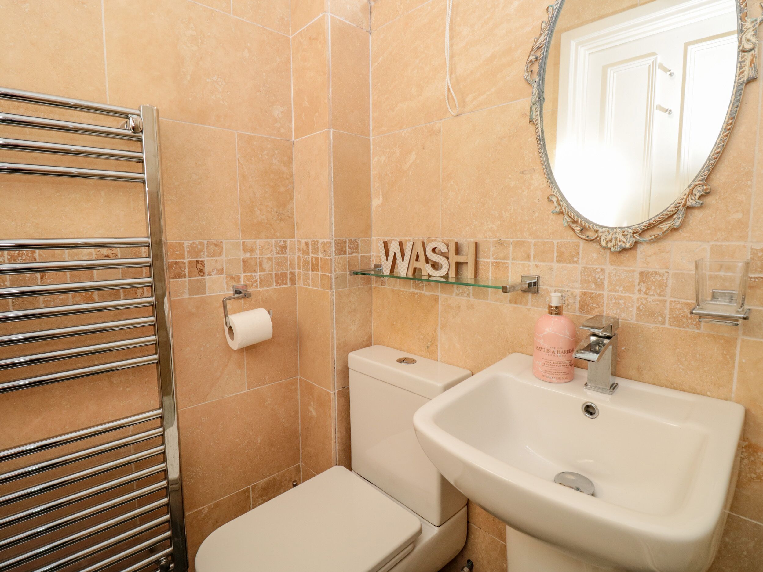 A bathroom with a toilet, sink, and towel rack.