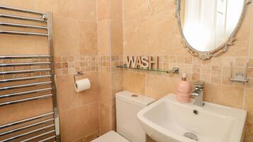 A bathroom with a toilet, sink, and towel rack.