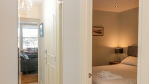 A hotel room with a bed, a nightstand, a lamp, and a picture on the wall. - River View (Dartmouth)