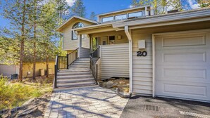 A two-story house with a front porch, a staircase, and a garage. - 20 Lassen Lane-Sunriver, Oregon: Hot Tub, BBQ, WiFi, SHARC Aquatics, Tubing Hill, Mt. Bachelor, Golf, Deschutes River, Tennis, Bike Paths (Bend)