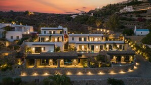 A modern villa with multiple levels, outdoor lighting, and a pool. - Noima Boutique Hotel Mykonos (Mykonos)