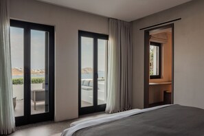 A hotel room with a large bed, a view of the sea, and a balcony with outdoor seating. - Noima Boutique Hotel Mykonos (Mykonos)
