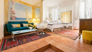 Ein Wohnzimmer mit Sofa, Sesseln, Couchtisch und einem Gemälde einer Statue.