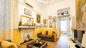 Un salon avec une cheminée, un canapé, une table basse et un téléviseur.