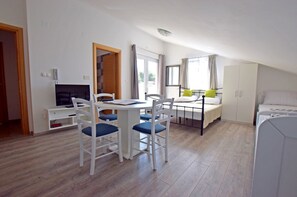 A room with a bed, a desk with a chair, a TV, and a window with curtains. - Modern studio for 4 people with a view of the mountains (Starigrad)
