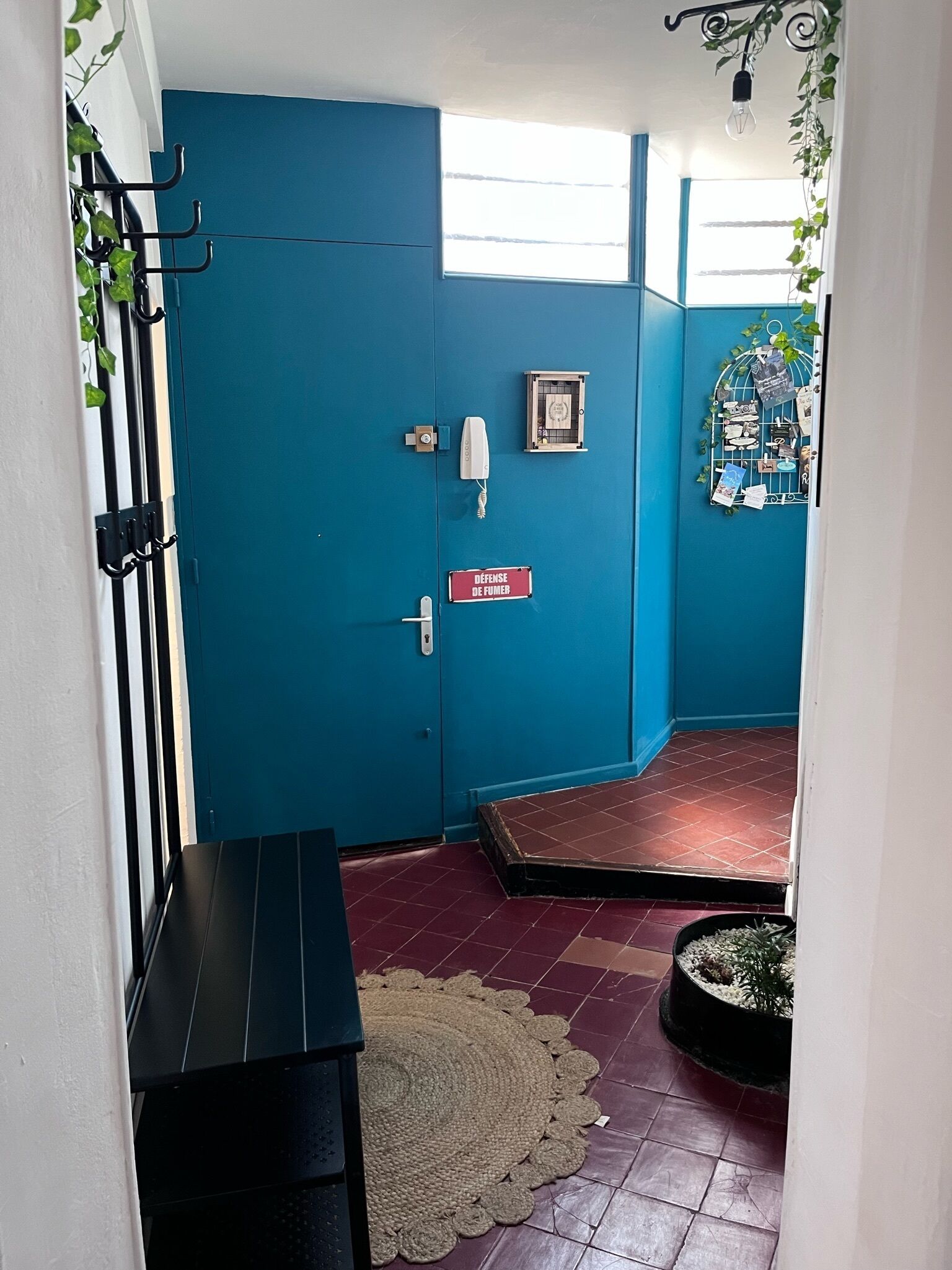 Puerta azul con teclado de seguridad y un letrero que dice "DEFENSE DE FUMEE".