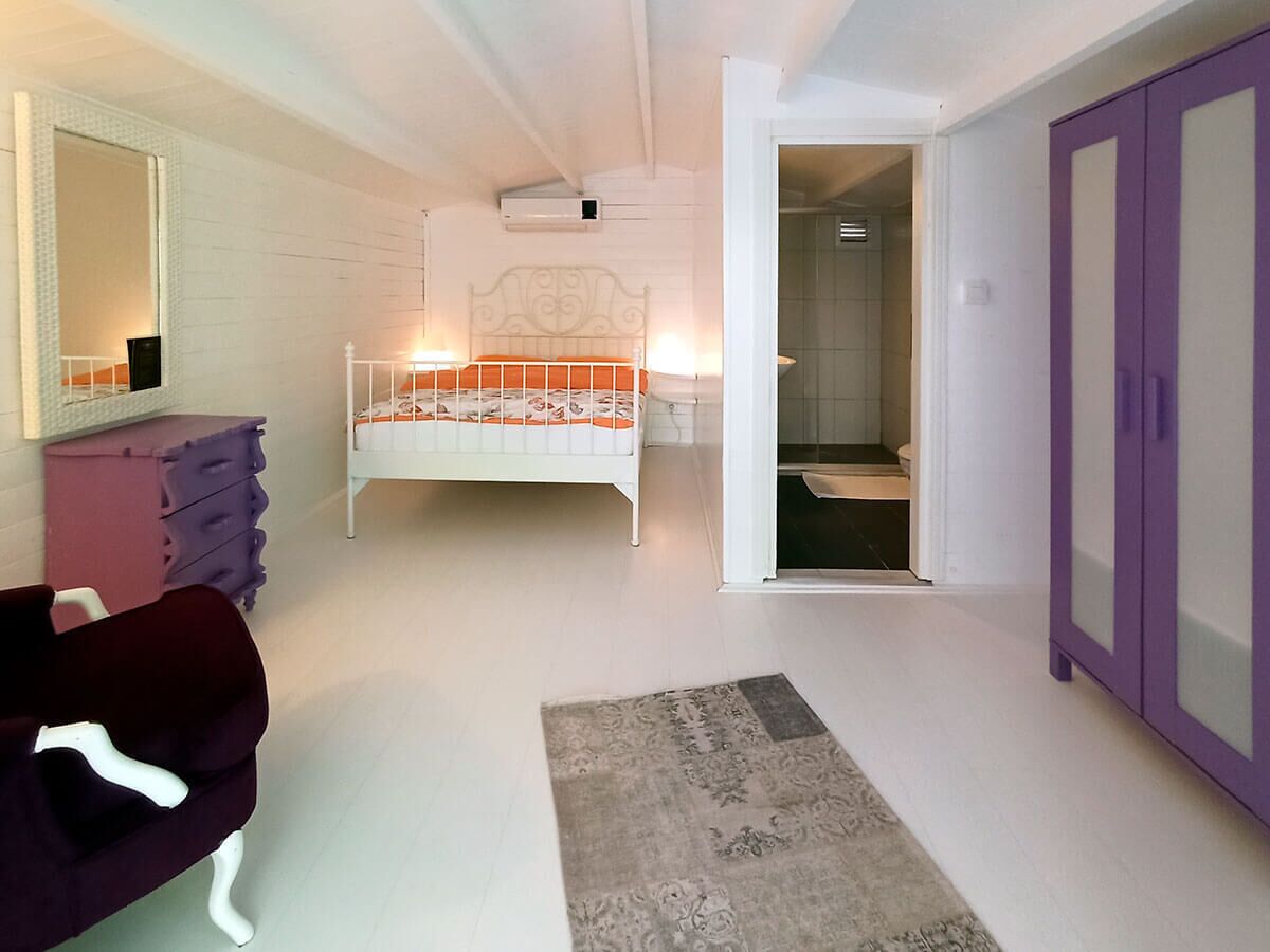 Une chambre à coucher comprenant un lit, une commode, une chaise et une armoire.
