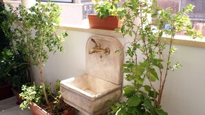 A vintage sink with a faucet, surrounded by potted plants on a balcony. - CASA GRANDE ALCALA HISTORIC CENTER (Catania)