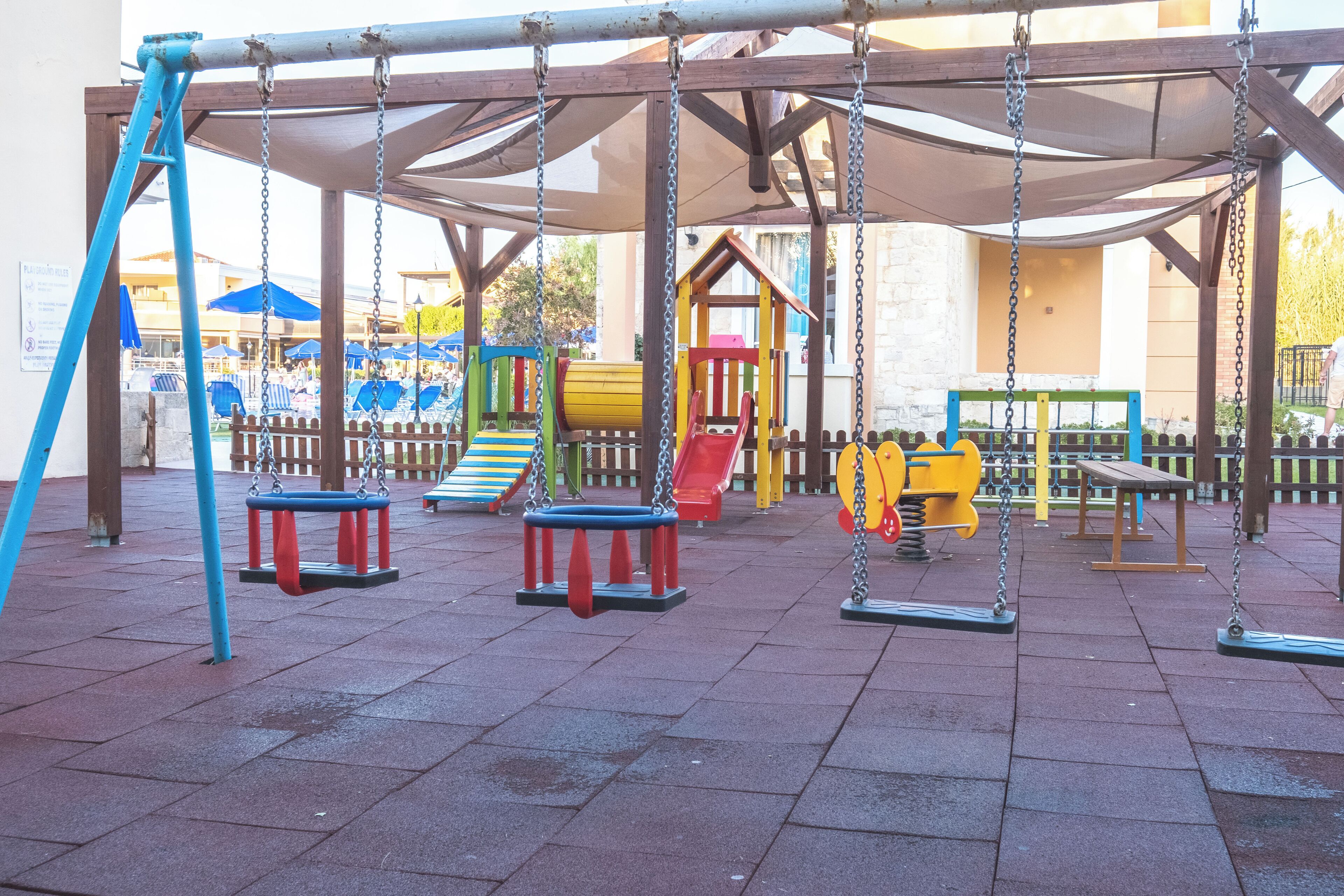 Un parque infantil con columpios y toboganes.