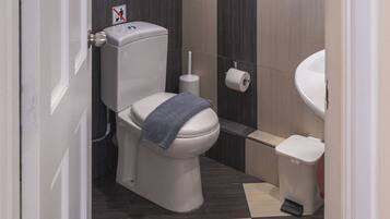 Un baño moderno con inodoro, bidé y lavabo.